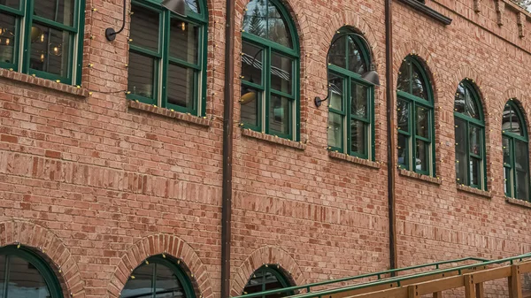 Pano Restaurant exterior in Park City with red brick wall and green arched windows