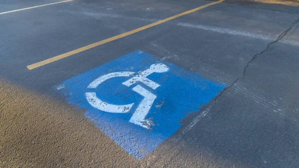Pano Handicapped parking space at a parking lot outside a building on a sunny day