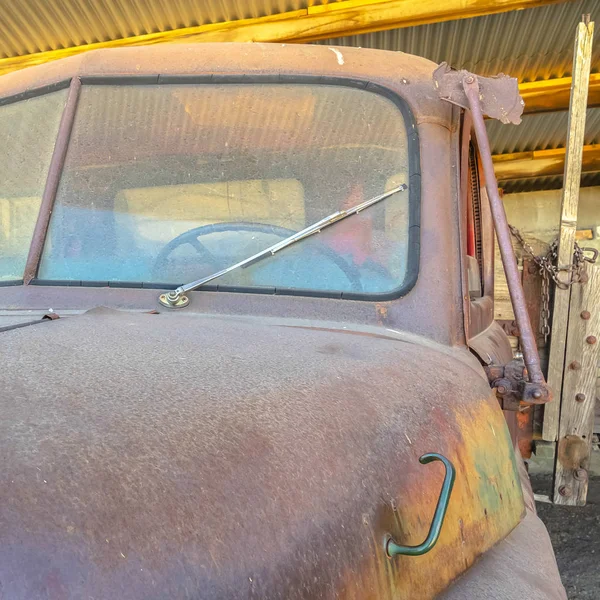 Cadre carré Vieille voiture vintage avec extérieur rouillé et sale à l'intérieur d'un garage avec toit métallique — Photo