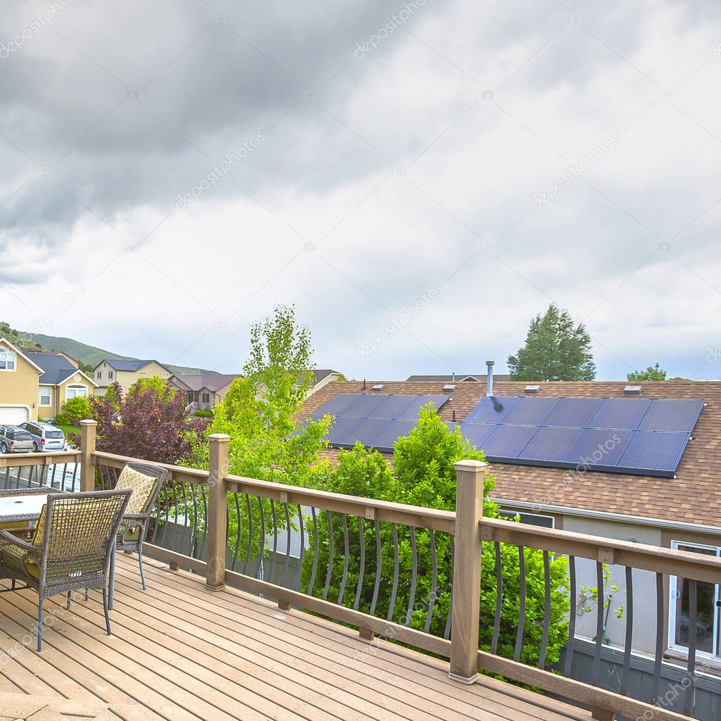 Square frame Deck overlooking solar panels on roof of home against mountain and cloudy sky