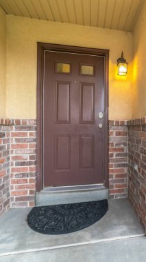 Beton ve tuğla dış duvarlı cam panelli dikey kahverengi kapı