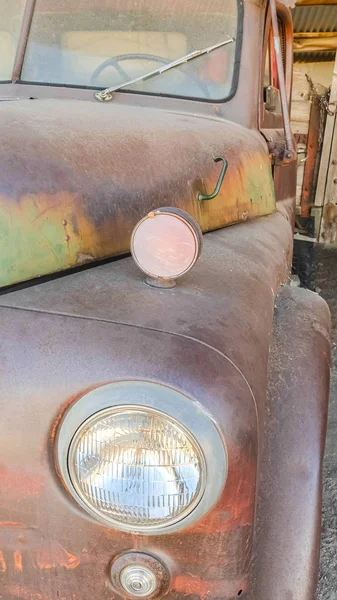 Вертикальный вид спереди на старый винтажный разъеденный автомобиль с ржавым и грязным внешним видом — стоковое фото