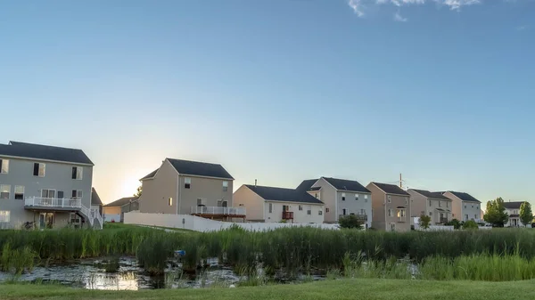 Marco Pano Puesta de sol en los suburbios con casas de varios pisos ovelookinga parque con estanque brillante — Foto de Stock