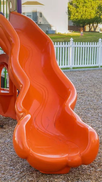 Vertical Close up of bright and shiny orange slide at a park with childrens playground — Stock Photo, Image