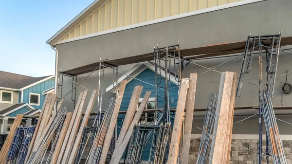 Pano-Wohnbau mit Baugerüst und Holzbalken gegen Hauswand — Stockfoto