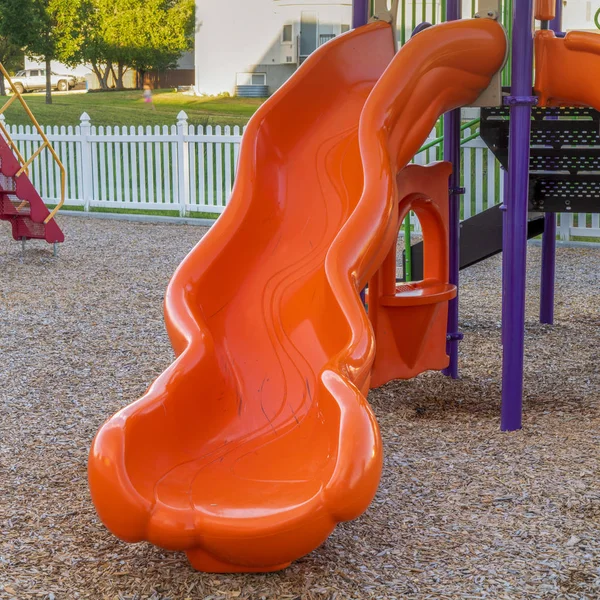 広場子供の遊び場のある公園で明るく光沢のあるオレンジ色のスライドの終わり — ストック写真