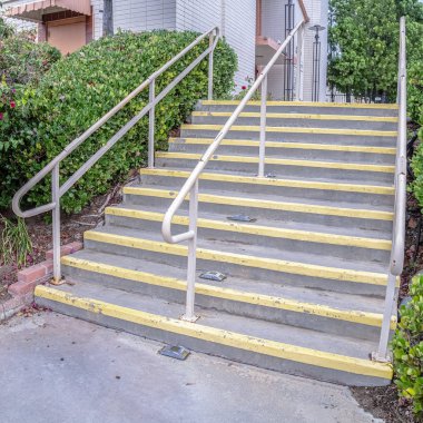 Kare çimento girişi. Güneşli bir günde sarı uyarı.