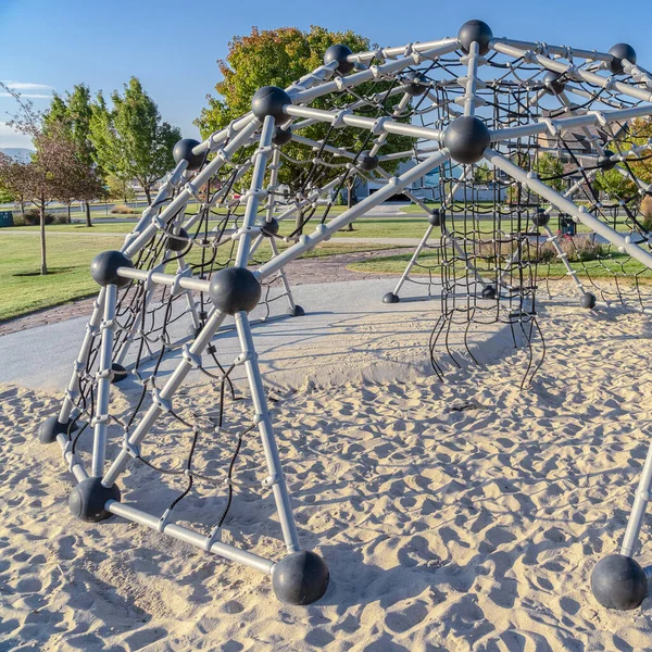 Square frame Dome shaped climbing frame in a sand pit