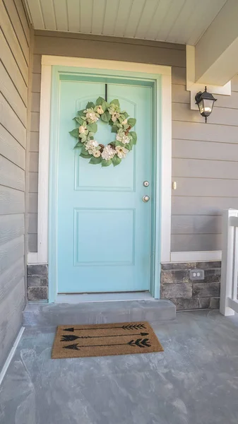 Verticaal Houten blauwe voordeur met krans op een zonnige dag — Stockfoto