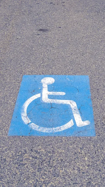 Ícone para deficientes verticais pintado no asfalto em um dia nublado — Fotografia de Stock