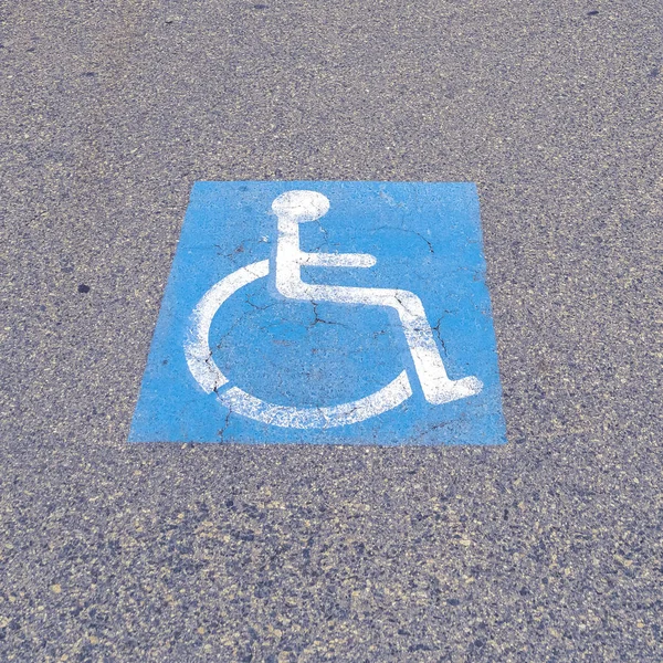 Cadre carré icône handicapée peinte sur le tarmac par une journée nuageuse — Photo