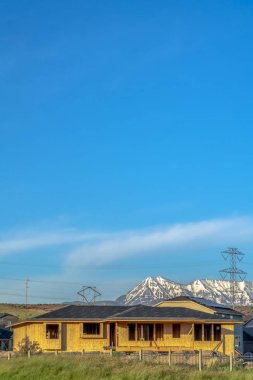 Karlı dağ ve mavi gökyüzü arkaplanlı yapım halindeki evin dışı