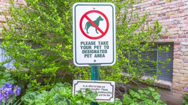 Panorama Yapraklara ve tuğla duvarlara karşı binanın dışındaki evcil hayvan tabelasına odaklan