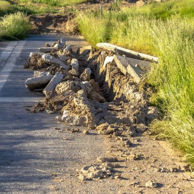 Güneşli bir günde hasarlı beton asfalt yolu manzaralı kare yol inşaatı