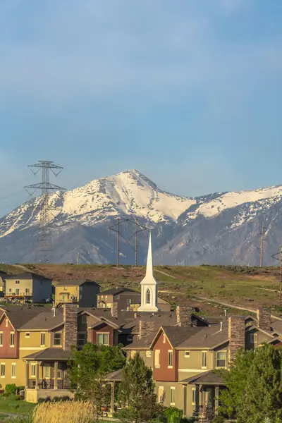 Casas e iglesia con paisaje escénico de montaña nevada y cielo azul — Foto de Stock