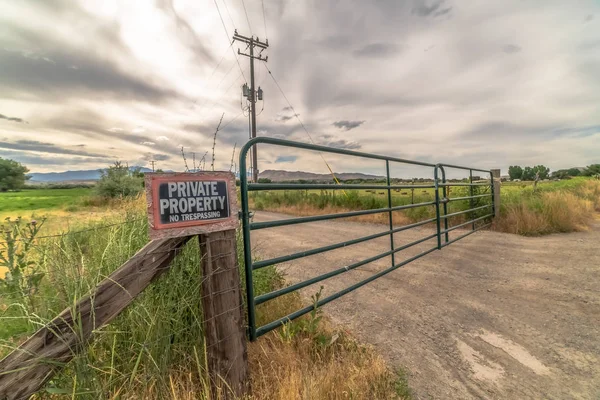 Puerta de seguridad y valla sin señal de invasión contra la montaña y el cielo nublado — Foto de Stock