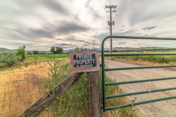 No Trespassing sign on the wire fence and green metal gate of private property — Stock Photo, Image