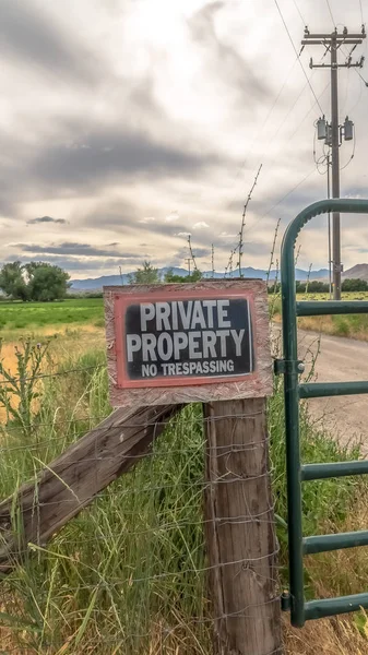 Vertical frame No Trespassing sign on the wire fence and green metal gate of private property — Stock Photo, Image