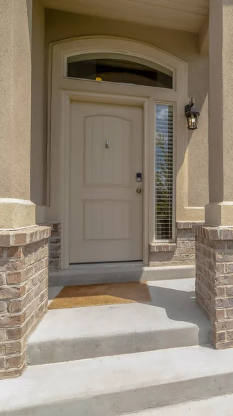Vertical frame Home entrance with steps white front door sidelight arched windows and yard