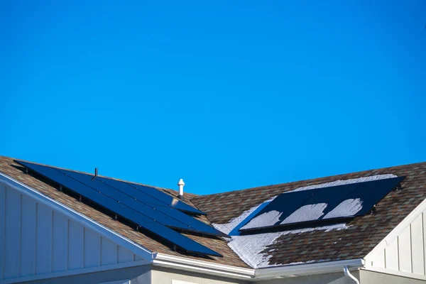 Nieve y paneles solares fotovoltaicos en un techo — Foto de Stock