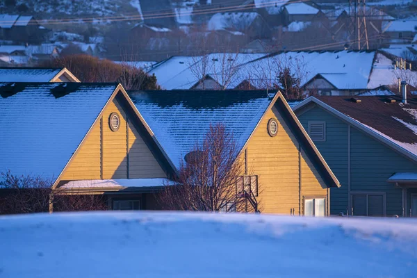 House roof covered in snow in golden evening light