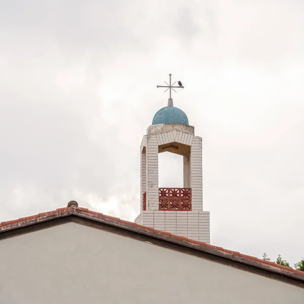 Marco cuadrado campanario de una iglesia cristiana contra el cielo nublado —  Fotos de Stock