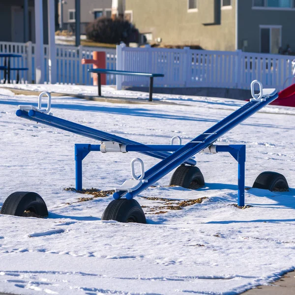 Square frame See-saws in a kids playground in winter snow