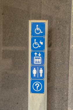 Binanın dış duvarına karşı metal plaka üzerinde çeşitli tabelalar var.