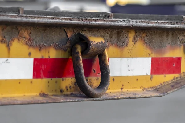 Närbild av en rostig metallring fäst vid sidan av en gammal och smutsig plattform — Stockfoto