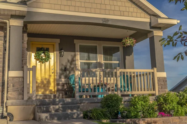 Inicio Fachada con puerta amarilla y porche delantero decorado con flores y plantas — Foto de Stock