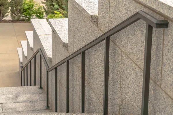 Наружная лестница здания с серыми металлическими поручнями напротив боковой стены — стоковое фото