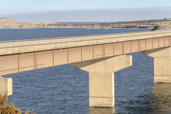 Stringer brug met schilderachtig uitzicht op blauw water en besneeuwd terrein in de winter — Stockfoto