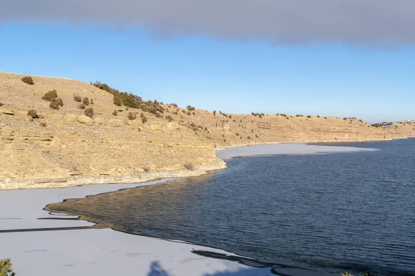 Scenic lake view with frozen water near the base of a rocky slope terrain — Stock Photo, Image