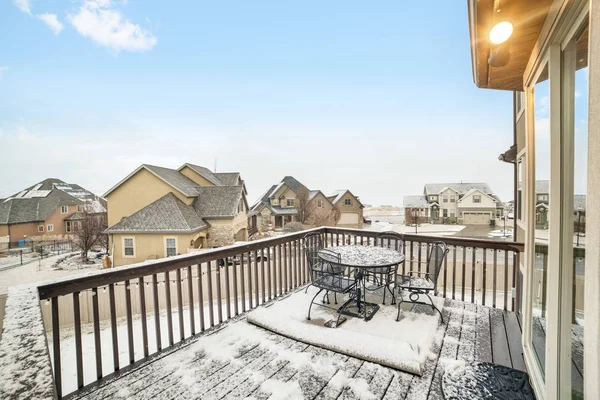 Snowy deck overlooking homes in the village blanketed with snow in winter