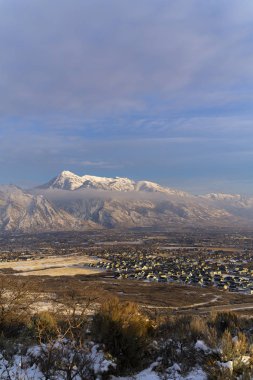 Tepe arazisi ve yerleşim alanı Timpanogos Dağı ve bulutlu gökyüzüne karşı