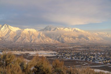 Timpanogos Dağı 'nın altında kışın bulutlu mavi gökyüzü olan evler.