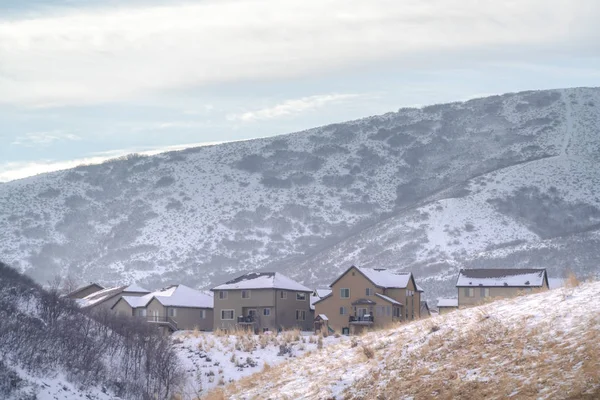 Casas nevadas en la cima de una colina con vistas panorámicas del paisaje cubierto de nieve en invierno — Foto de Stock