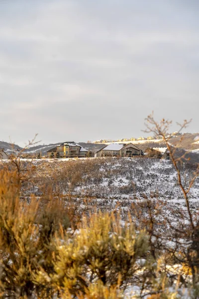 雪に覆われた地形に囲まれた丘の上の家空の背景 — ストック写真