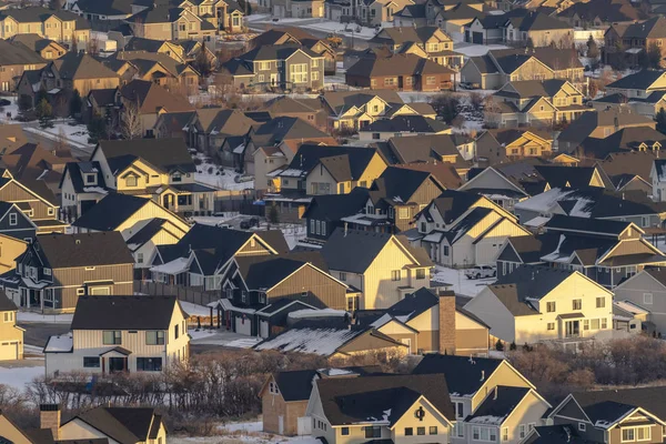 Häuser mit verschneiten Dächern und verschneiten Höfen, die im Winter vom Sonnenlicht erleuchtet werden — Stockfoto