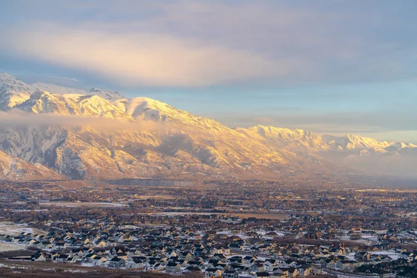Karlı Timpanogos Dağı gün batımında altın güneş ışığıyla aydınlatılıyor.