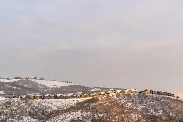 Casas en la colina con vista panorámica del terreno nevado y la belleza natural al atardecer — Foto de Stock
