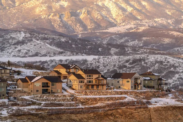 Puesta de sol iluminando casas en el barrio cubierto de nieve en invierno — Foto de Stock