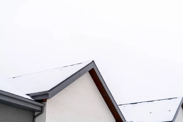 Home exterior com vista de perto para o telhado gable coberto com folha de neve — Fotografia de Stock