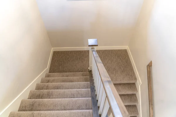 Escalier en forme de U avec mains courantes et tapis gris à l'intérieur d'une maison avec mur blanc — Photo