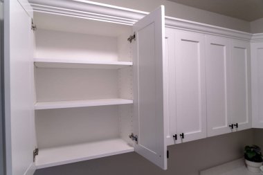 Dekoratif kalıplı ve siyah saplı tahta dolabı aç.