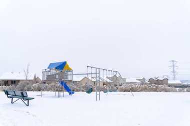 Kışın karla zıtlaşan canlı oyun parkı olan mahalle parkı