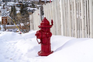 Kışın Utah Park City 'deki kar ve tepe evlere karşı kırmızı yangın musluğu.