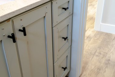 Banyonun içinde siyah saplı ve beyaz tezgahlı makyaj dolabı.