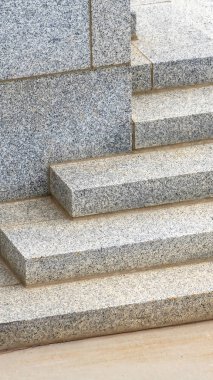 Güneşli bir günde bir binanın köşesinden geçen dikey kare merdiven.