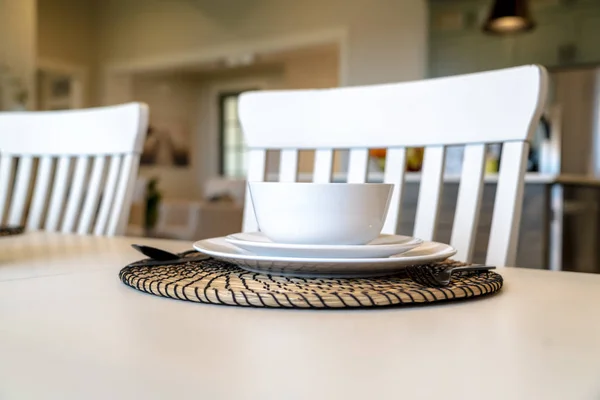 Configuração de mesa na mesa de jantar familiar com utensílios de mesa brancos e placemat redondo — Fotografia de Stock